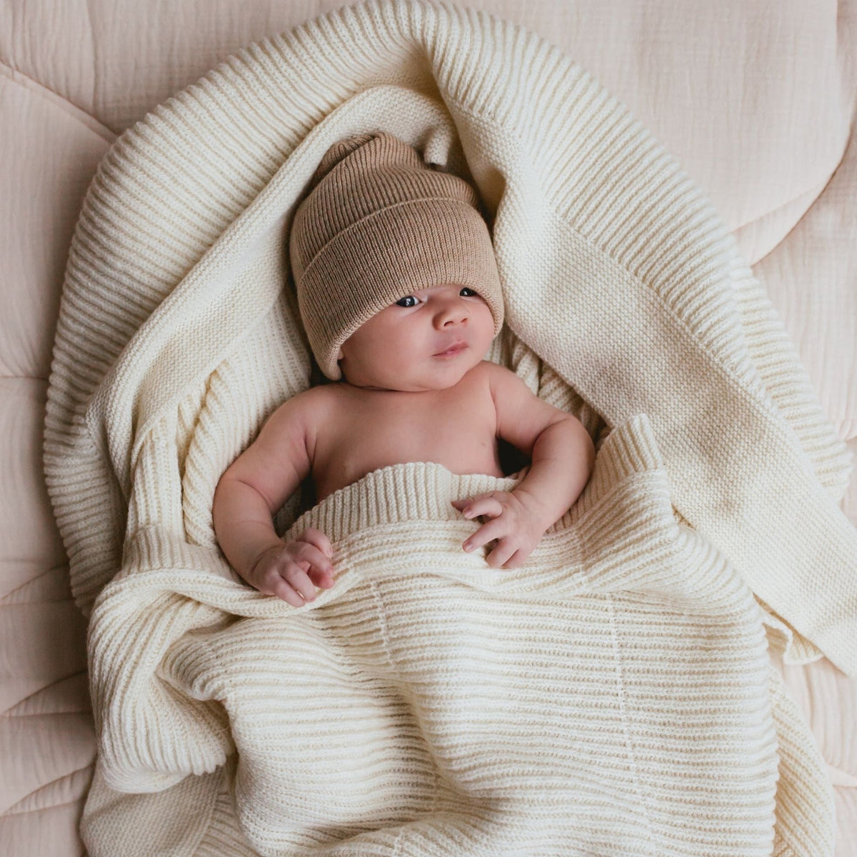 Ledikant deken Gaston Soft Beige baby in deken gewikkeld.